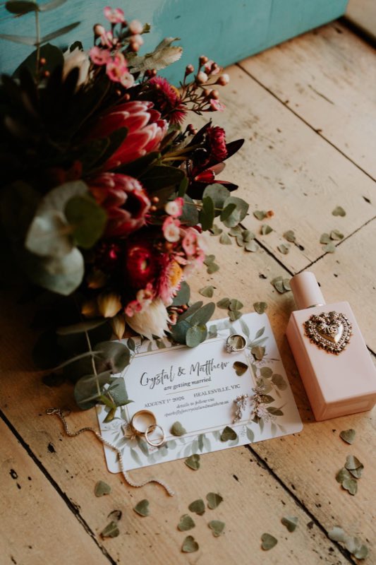 Flat lay of a wedding invitation beside a posy of natives and eucalyptus